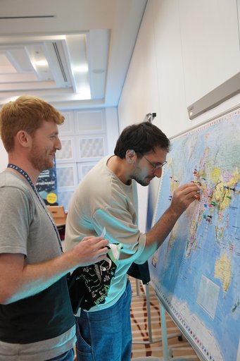 MPSP students look at a world map and pinpoint their hometowns